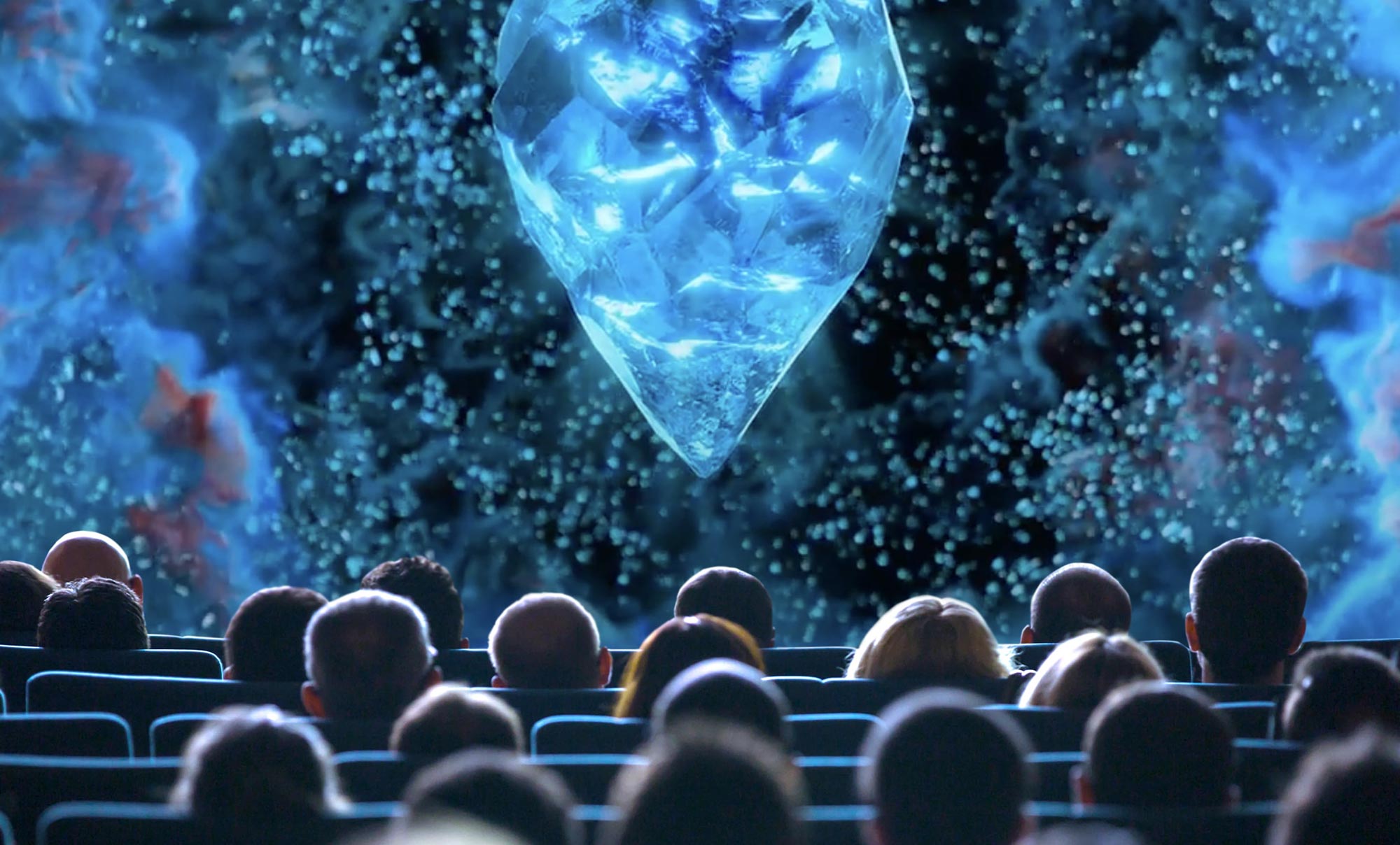 People in a movie theatre viewing a crystal on the screen.